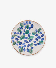 Midnight Garden Serving Bowl crafted from ceramic, featuring a beige background and adorned with a hand-painted design of green leaves and blue oval-shaped fruits inspired by traditional Fayoum pottery.