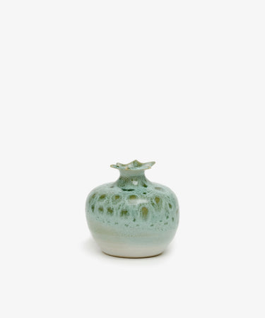 The Pom Bud Vase features handmade ceramic craftsmanship, a narrow wavy-edged opening, and a glossy green glaze—an elegant Granada ceramics decor piece set against a plain white background.