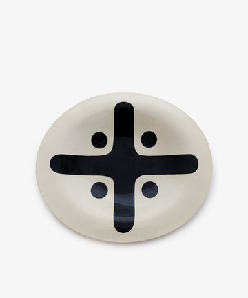 Motif 5, Oval is a handcrafted ceramic plate featuring a black geometric cross with four dots on a white background—ideal for stylish decorative platters.
