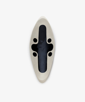 Motif 1, Point is a handcrafted, boat-shaped ceramic sculpture featuring a smooth white exterior and multiple black oval openings inside, shown from above against a plain background.