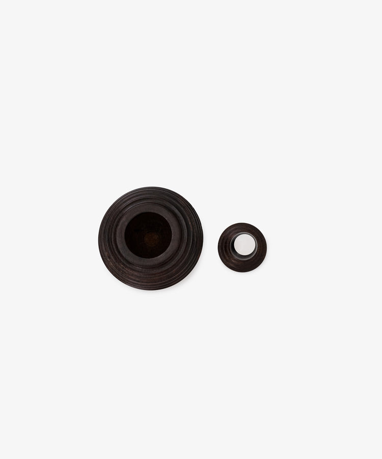 Two round, dark brown Curiosity Boxes of varying sizes, featuring concentric grooves, are displayed side by side on a plain white background.