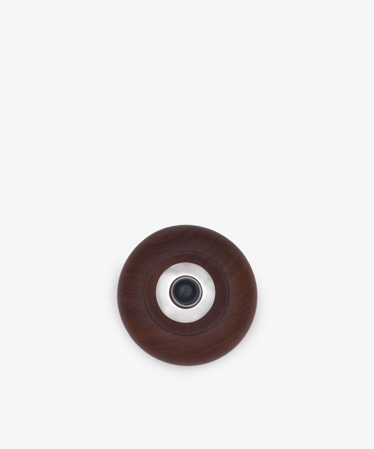 A top-down view of Curiosity Box 11, a vintage decorative box crafted from dark brown African wood with a central metallic and black circular detail, displayed against a plain white background.