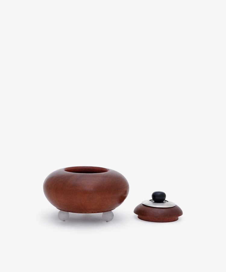 The Curiosity Box 11 is a round African wood box with three small legs, shown with its matching lid beside it on a plain white background.