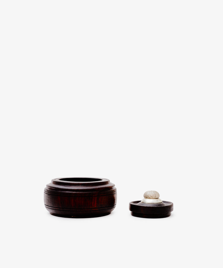 The Curiosity Box, a small round African wood box with its lid beside it on a plain white background, makes a perfect collectible keepsake for any decor.