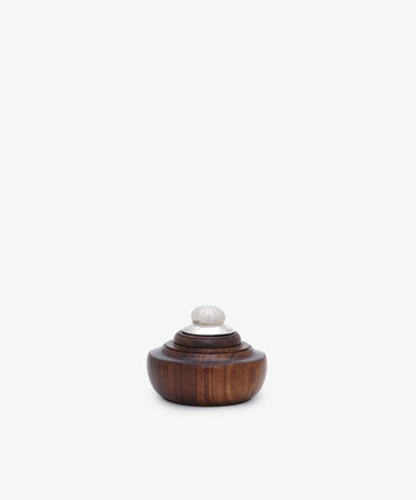 The Curiosity Box 16 is a small, round African wood box with a dark finish, featuring a tiered lid and silver knob, pictured on a plain white background.