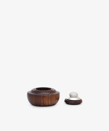 The Curiosity Box 16, a small round African wood box with a separate lid and silver decorative knob, is displayed on a plain white background.