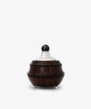 The Curiosity Box is a restored vintage round container crafted from dark African wood with sterling silver accents—a silver lid, spherical knob, and three elegant feet—shown against a plain white background.