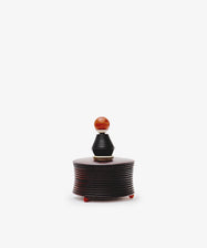 The Curiosity Box is a small, round African wood box with ridged sides, a lid, and an orange knob handle—a charming vintage keepsake for your treasured items.