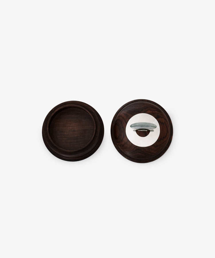 Two round dark wood Curiosity Boxes—one open with an empty base, the other closed with a metal handle—sit against a plain white background. These restored vintage keepsake boxes bring timeless elegance to any space.