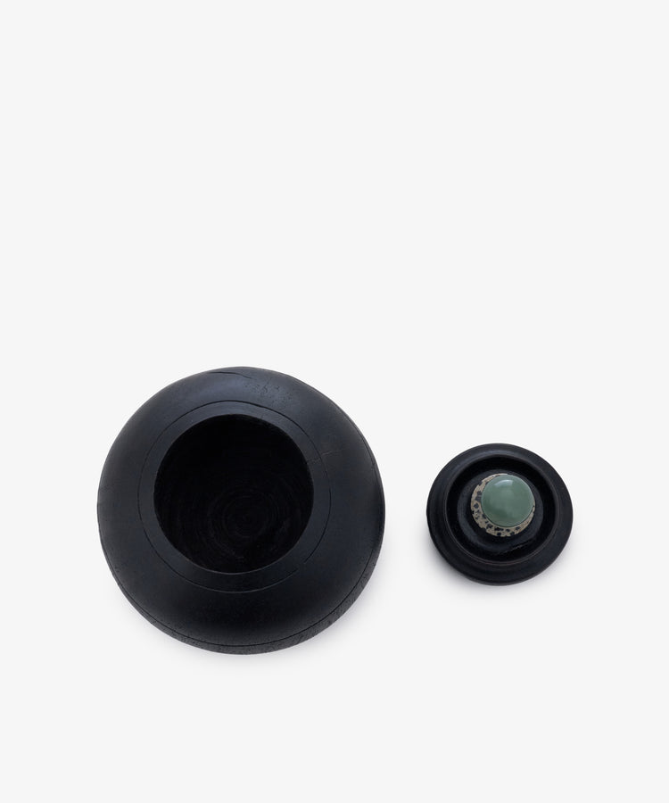 Two black spherical Curiosity Box 2 objects rest on a white background: one large, hollow with an open top; the other smaller, topped with a green circular cap.