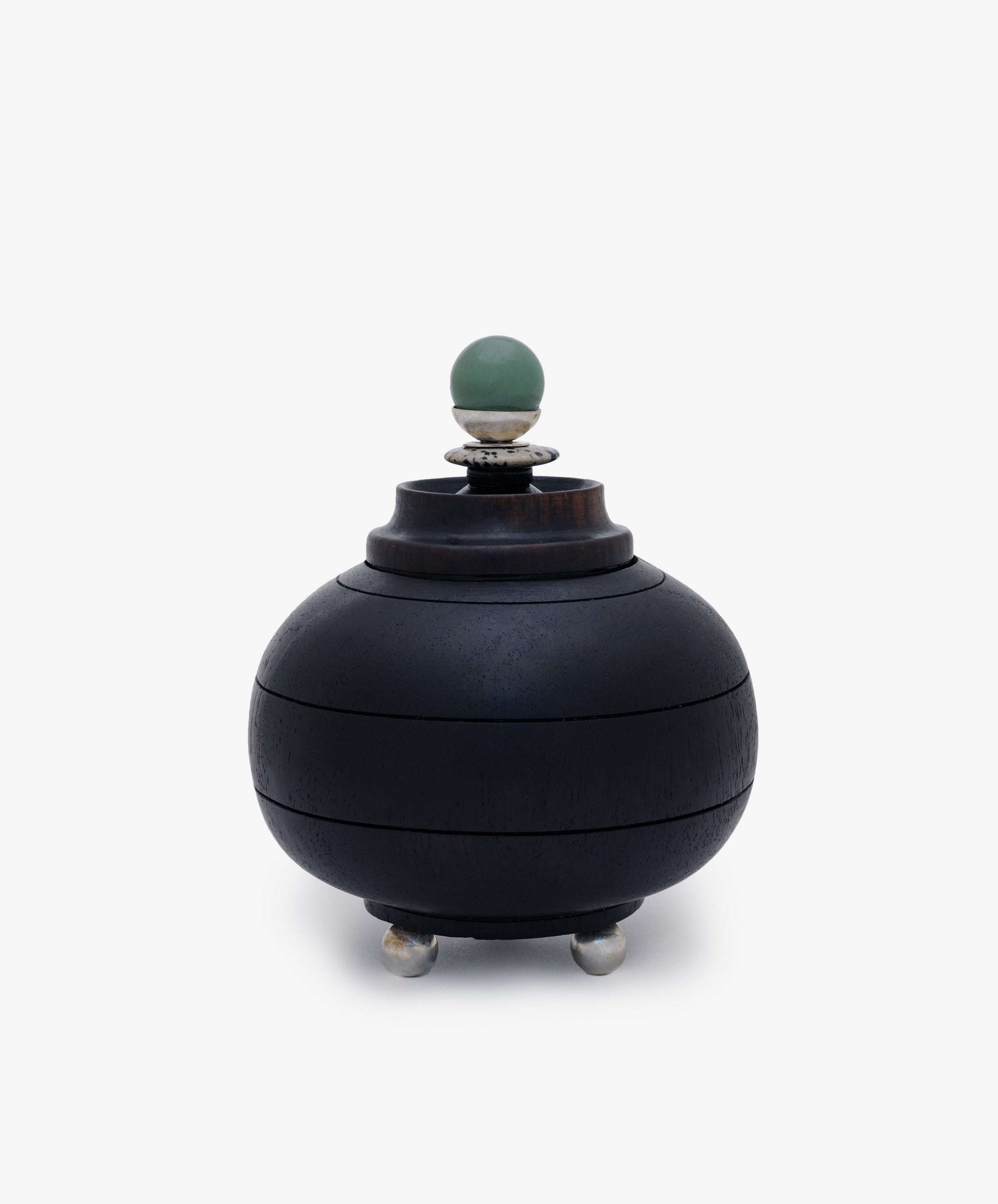 Curiosity Box 2: A round black African wood box with a lid, silver feet, and a green spherical handle on top, displayed against a plain white background.