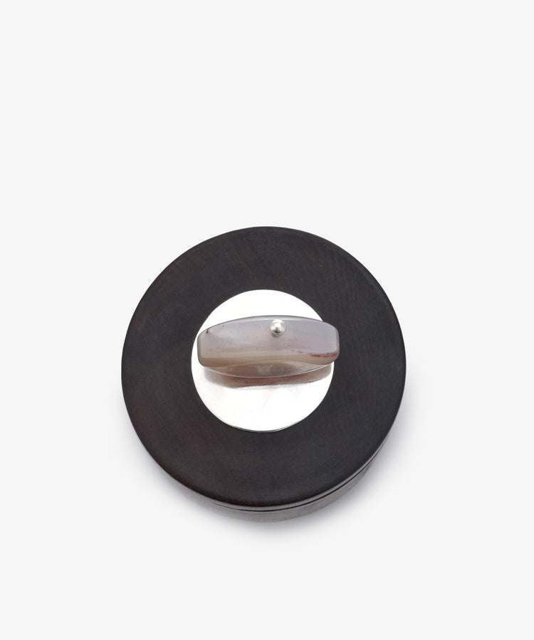 Curiosity Box 3 features a round black and silver brooch with a horizontal translucent stone bar at its center, shown on a white background—ideal for keeping in your special art keepsake box.