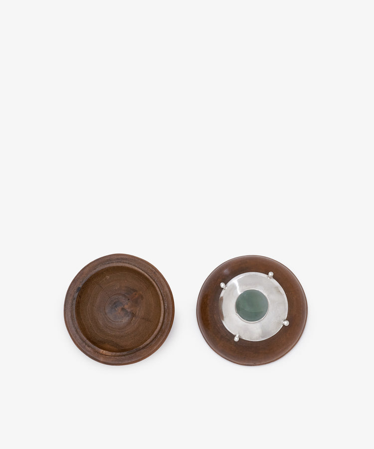 Two small round brown dishes from Curiosity Box 6 are shown; one is plain inside like an African wood box, while the other features a central metal and green inlay.