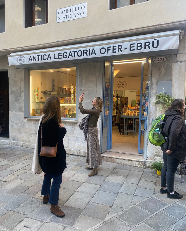 woman taking photo outside of store on the street