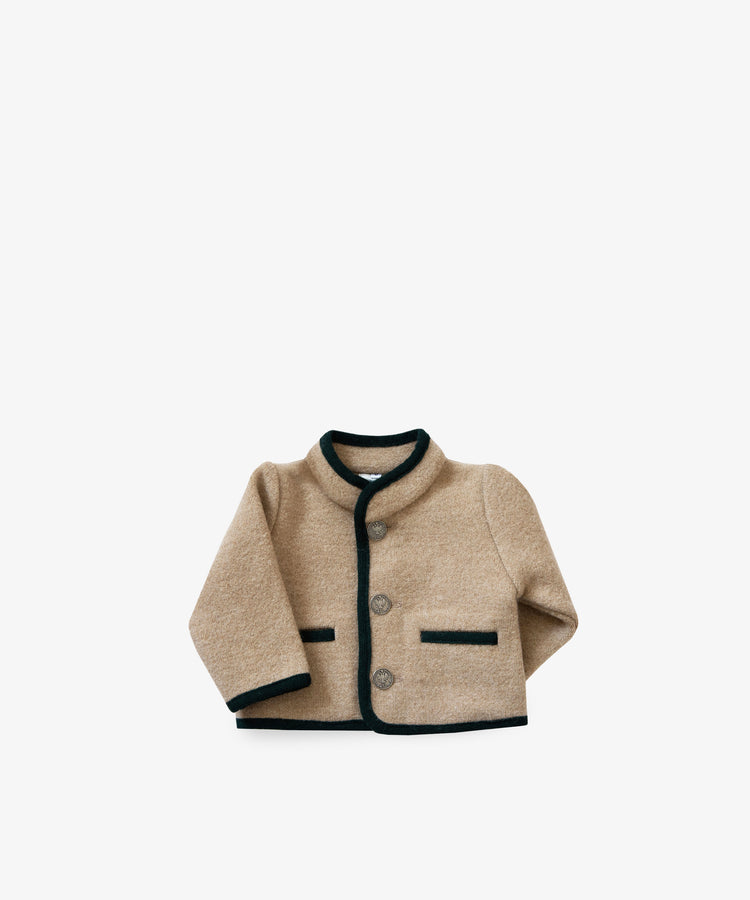 The Austrian Wool Jacket is a beige wool toddler jacket with black trim, Nehru collar, three front buttons, and two black-edged pockets, inspired by Austrian children’s styles. Displayed on a plain white background.