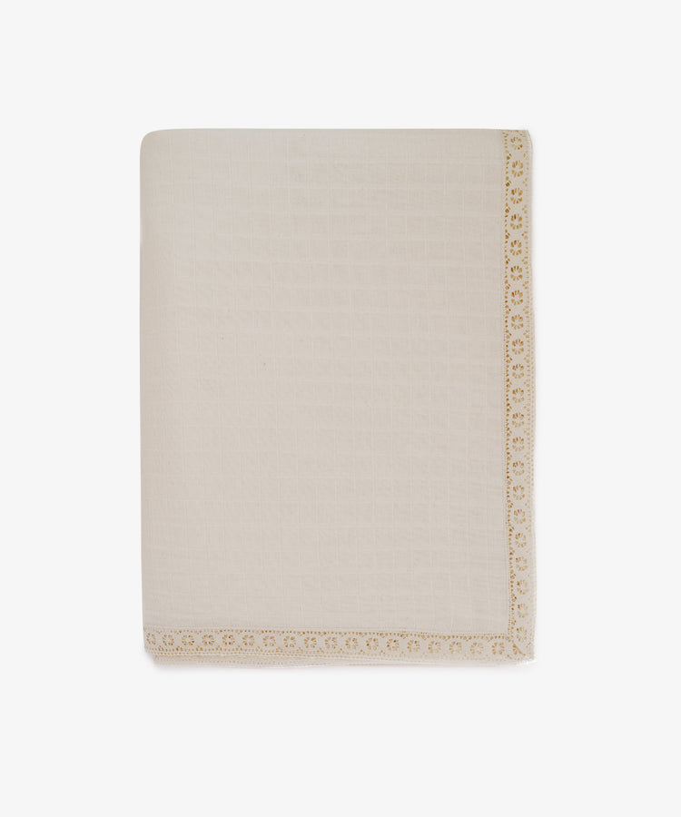 The Double Gauze Flower Tablecloth is cream-colored with a textured surface and features decorative yellow lace trim along one edge, displayed folded against a white background.