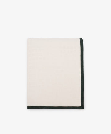 A white tablecloth featuring a decorative green trim along the edges.