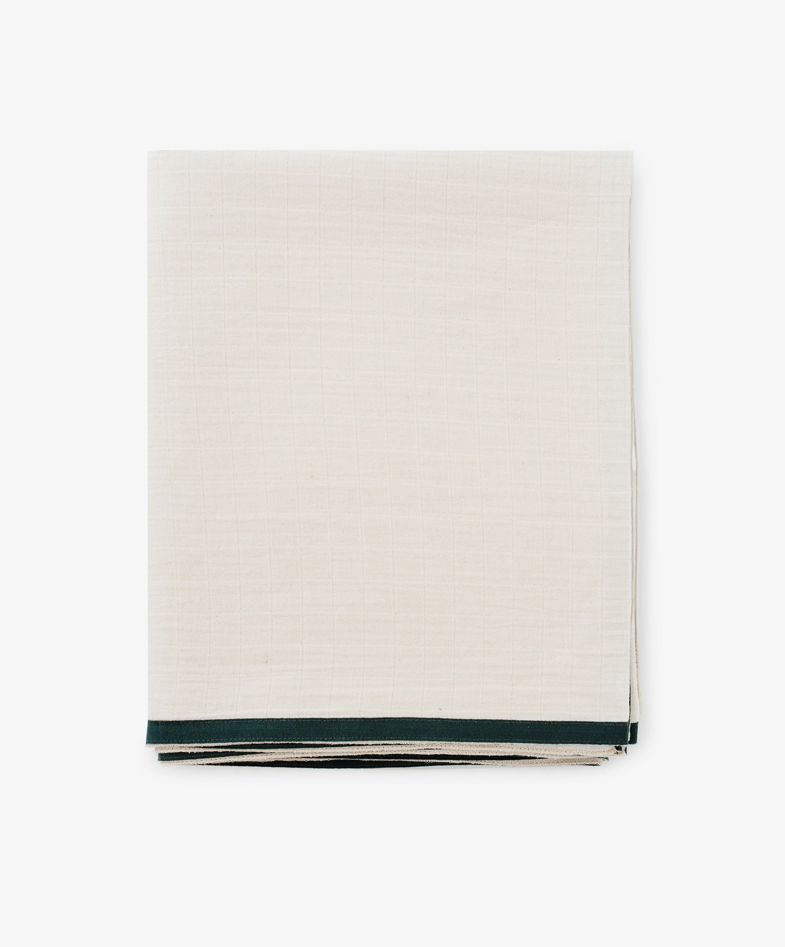 The Fita Tablecloth, made from natural cotton, features a neatly folded off-white fabric with a thin dark green border and is displayed on a plain white background.