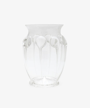 The Carlotta Vase is a clear, mouth-blown piece with a flared rim and vertical embossed patterns, set against a plain white background and highlighting Bohemian artistry.