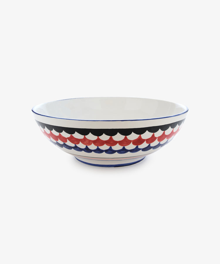 Palio Serving Bowl. Large white glazed ceramic bowl with blue and red accents, side view.