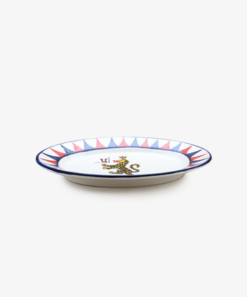 Palio Serving Platter. Glazed ceramic oval plate in red and blue designs with panther motif, side view.