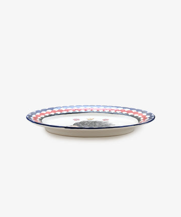 Palio Serving Platter. Glazed ceramic oval plate in red and navy designs with porcupine motif, side view.