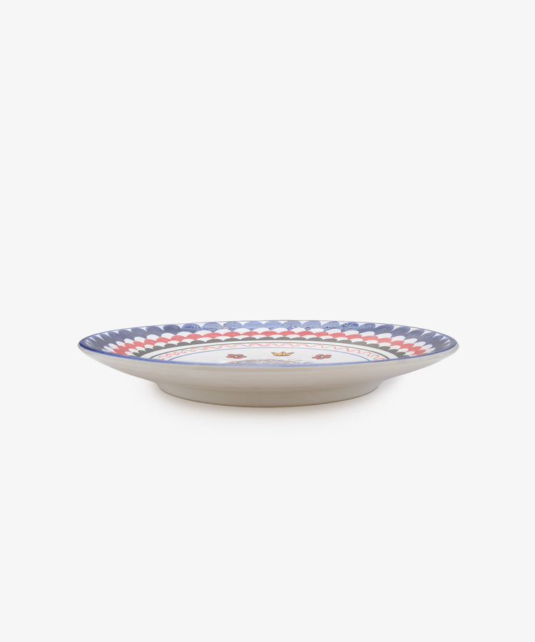 Palio Round Serving Platter. Large white glazed ceramic plate with blue and red accents and porcupine motif, side view.