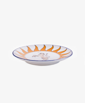 Palio Round Serving Platter. Large white glazed ceramic plate with orange and blue accents, side view.