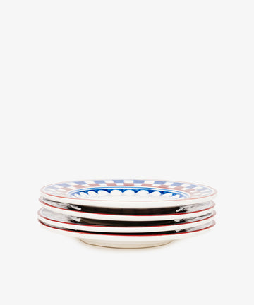 The Luca Small Plate set includes four hand-painted ceramic plates featuring red rims and a blue-and-white checkered pattern with traditional motifs.