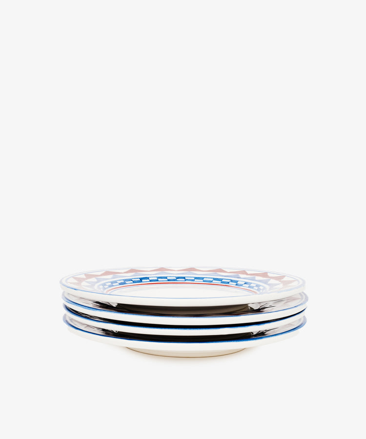 The Luca Small Plate, Set of 4, features PORTA designs with blue and reddish-brown rim patterns inspired by the Palio horse race, all set against a crisp white background.