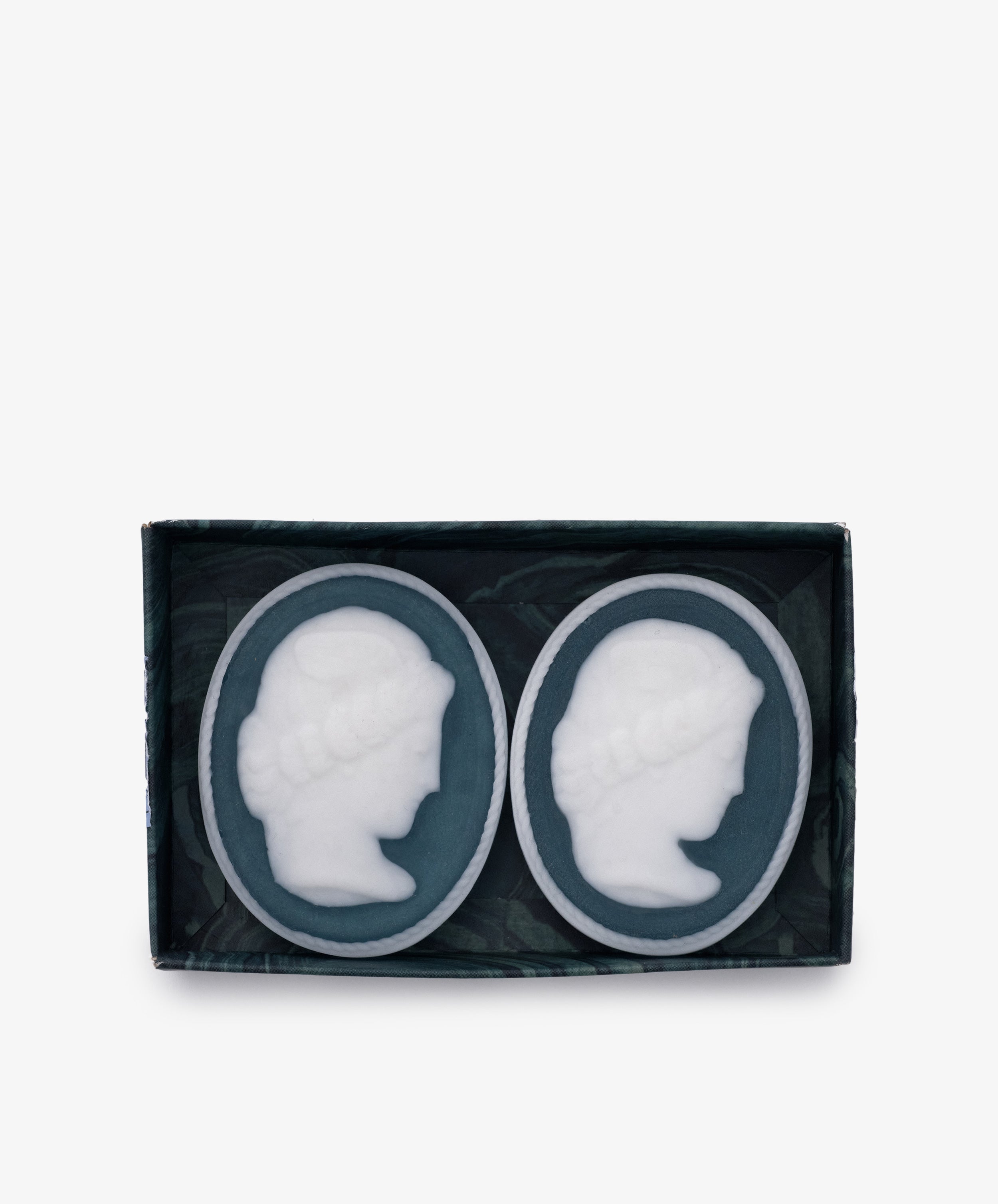 The Diana Soap, Set of 2, features oval-shaped soaps with white embossed cameo profiles, elegantly arranged in a rectangular box—an exquisite touch for any luxury bathroom.