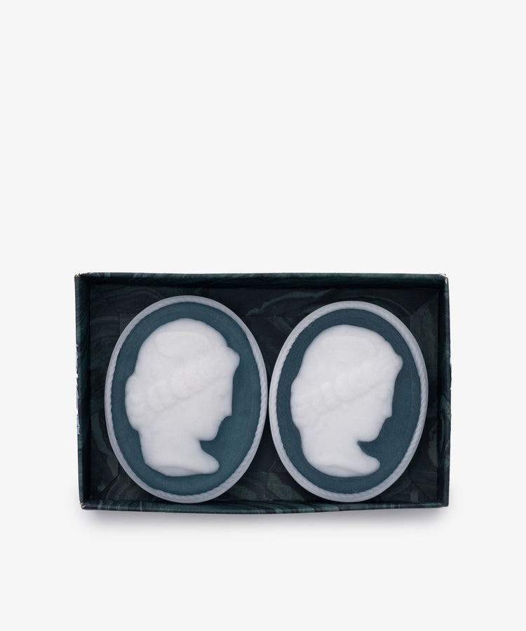 The Diana Soap, Set of 2, features oval-shaped soaps with white embossed cameo profiles, elegantly arranged in a rectangular box—an exquisite touch for any luxury bathroom.