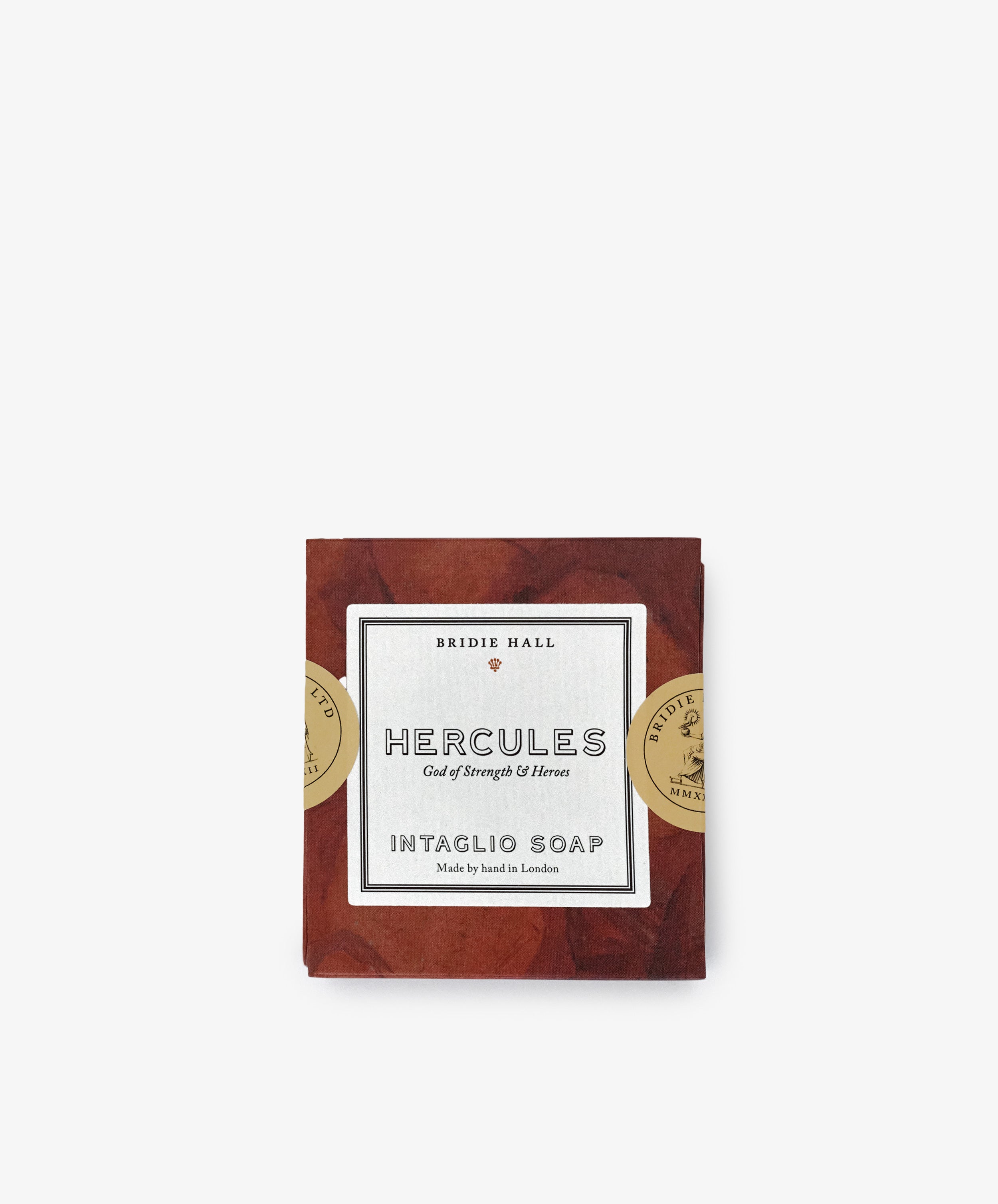 Hercules Soap features a decorative label with gold seals, sculpted design, and comes wrapped in brown paper—shown here against a white background.
