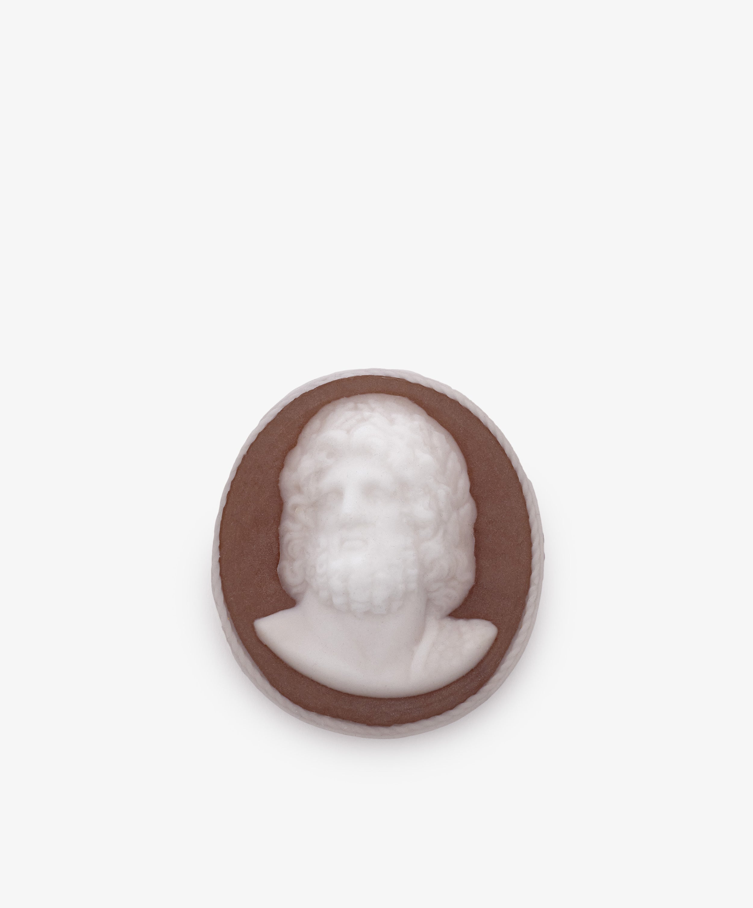 A round brown and white Hercules Soap, featuring a raised profile of a bearded man with curly hair—hand-poured in London—perfect for classical bathroom decor or as an inspiring accent.