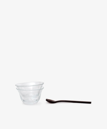 Two clear bowls from the Sweet Treat Bundle are stacked together beside a dark Lungo spoon and fork, all set on a plain white background—ideal for assembling your own Valentine’s Day bundle.