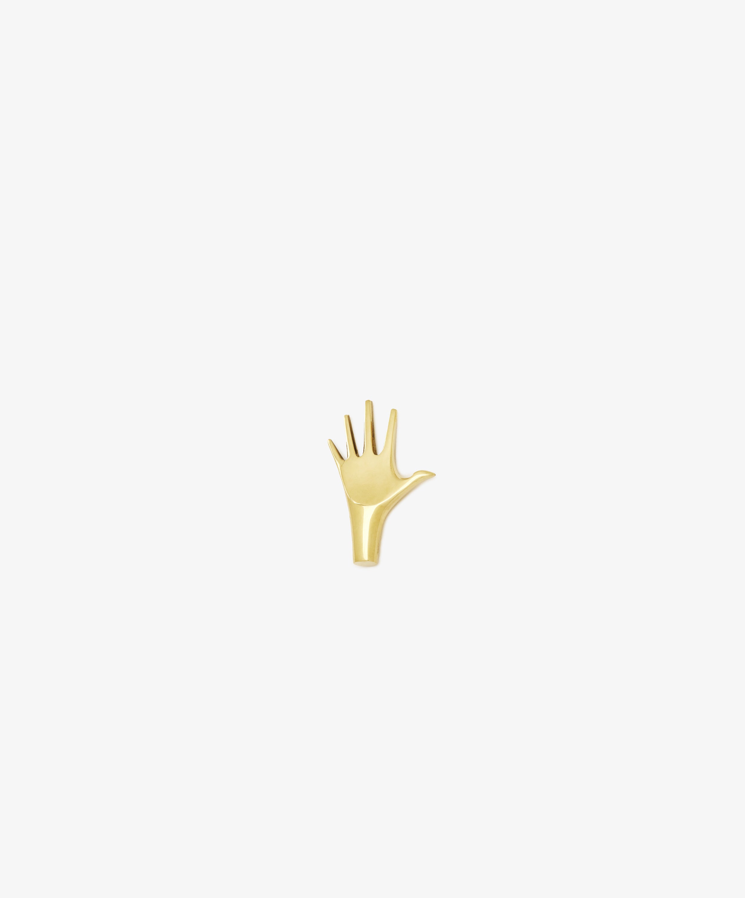The Hand Paperweight, inspired by Viennese modernism, features five outstretched fingers in gold Auböck brass and is displayed on a plain white background—an iconic sculptural design.