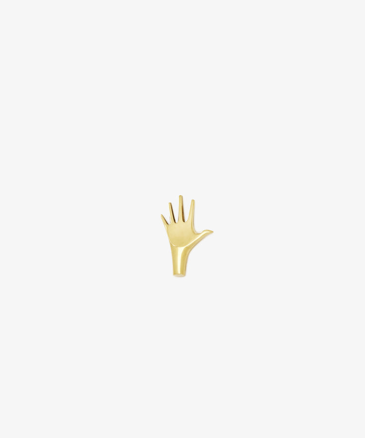 The Hand Paperweight, inspired by Viennese modernism, features five outstretched fingers in gold Auböck brass and is displayed on a plain white background—an iconic sculptural design.