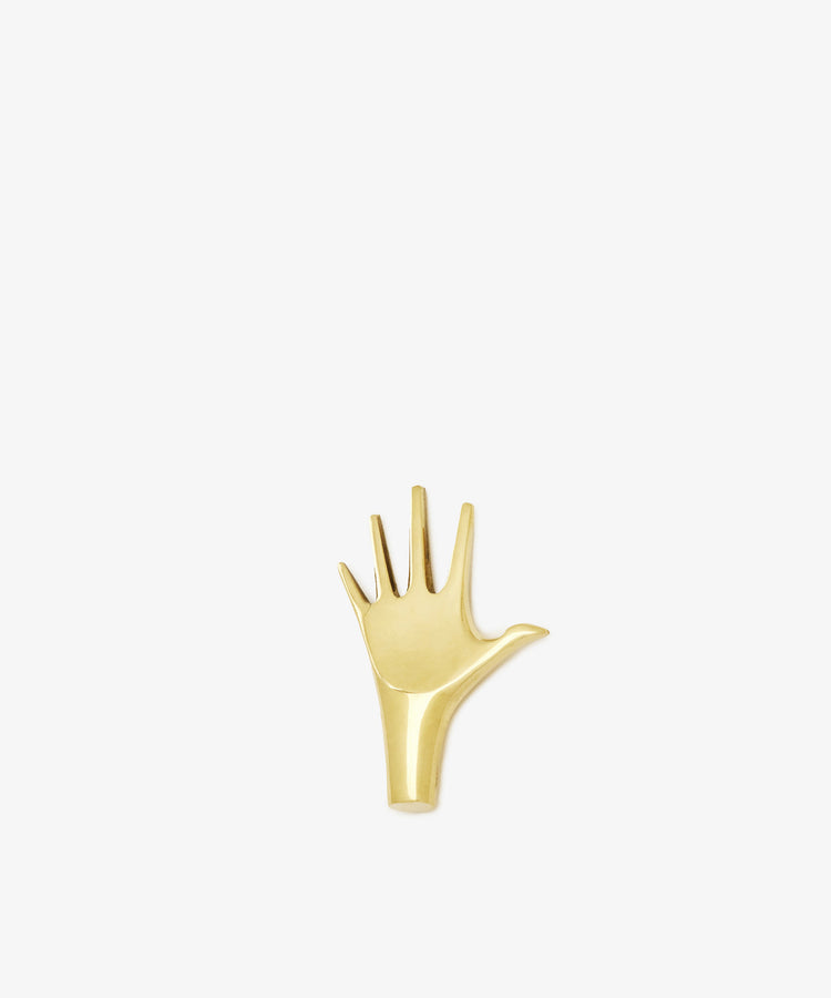 The Hand Paperweight is a solid brass, gold-colored sculptural object shaped like an open hand with five fingers, inspired by Viennese modernism and shown on a plain white background.