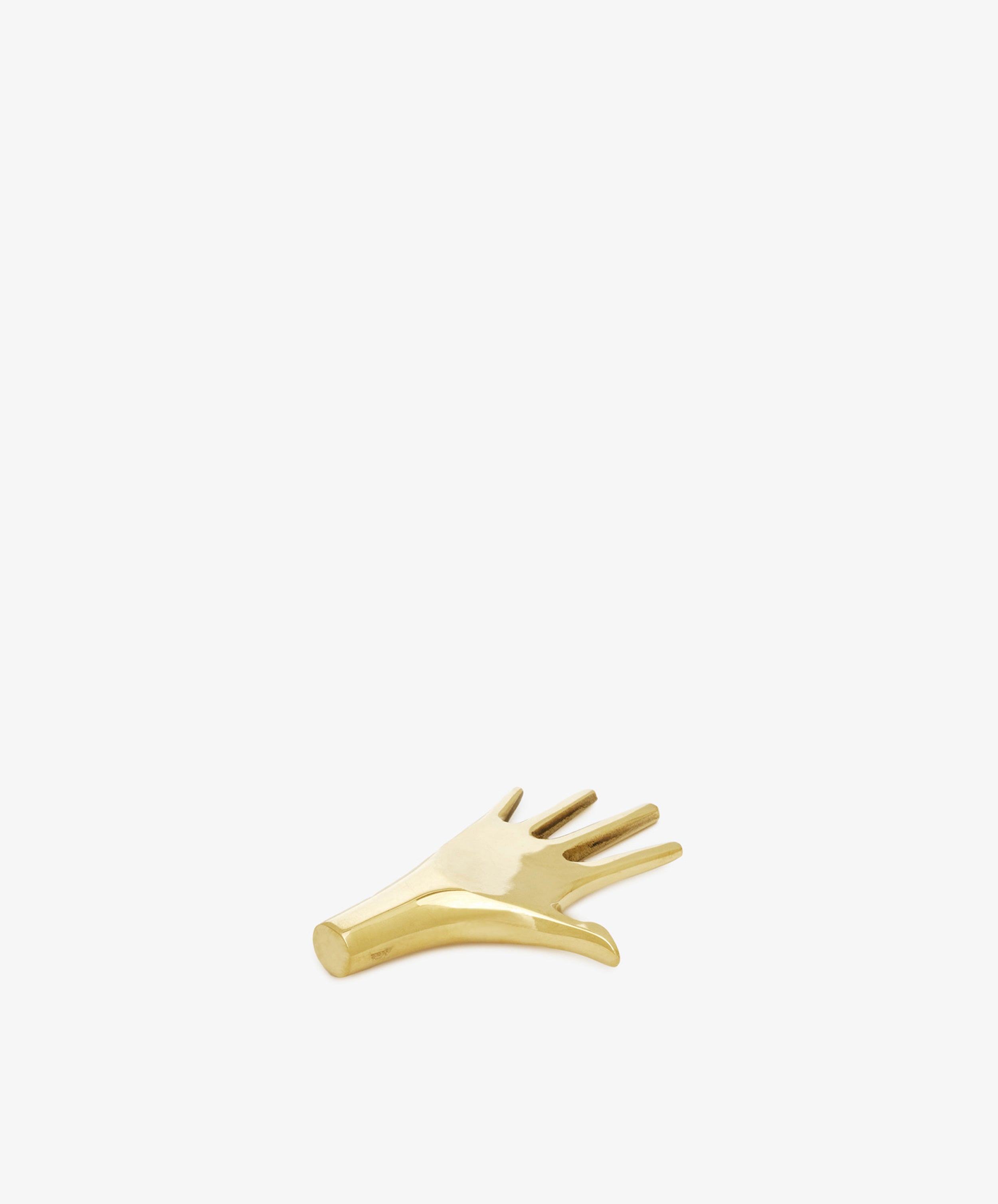 The Hand Paperweight is a small, gold-toned solid brass accent shaped like a stylized hand with extended fingers, inspired by Viennese modernism and shown on a plain white background.