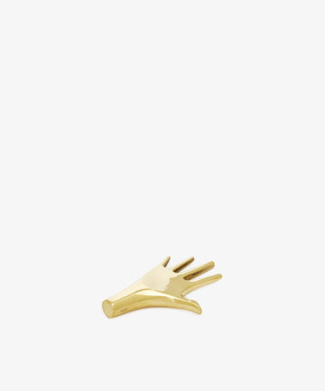 The Hand Paperweight is a small, gold-toned solid brass accent shaped like a stylized hand with extended fingers, inspired by Viennese modernism and shown on a plain white background.