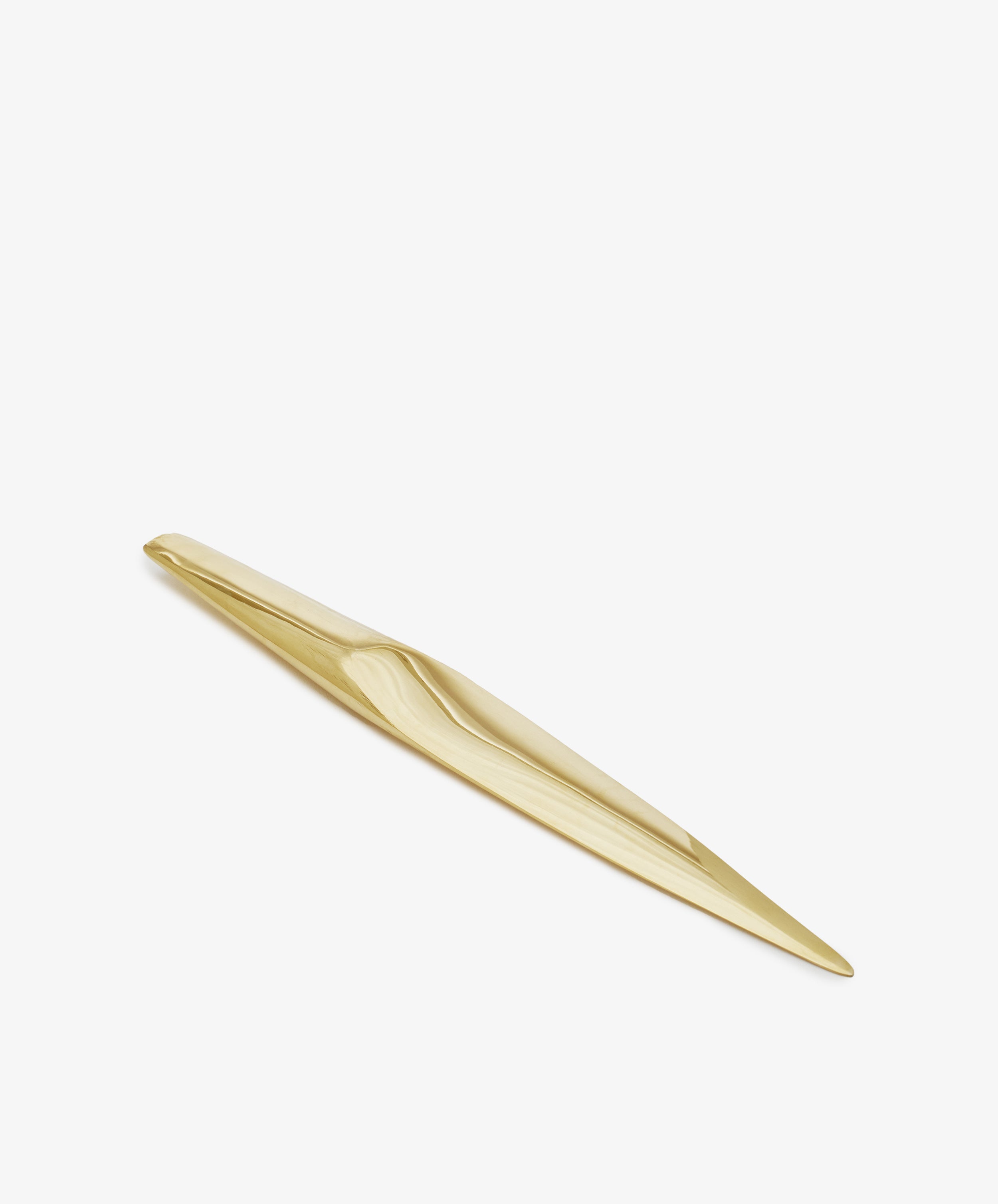A gold-colored, elongated, and sleek metal Letter Opener—possibly solid brass or a sculptural desk accessory—photographed on a white background.