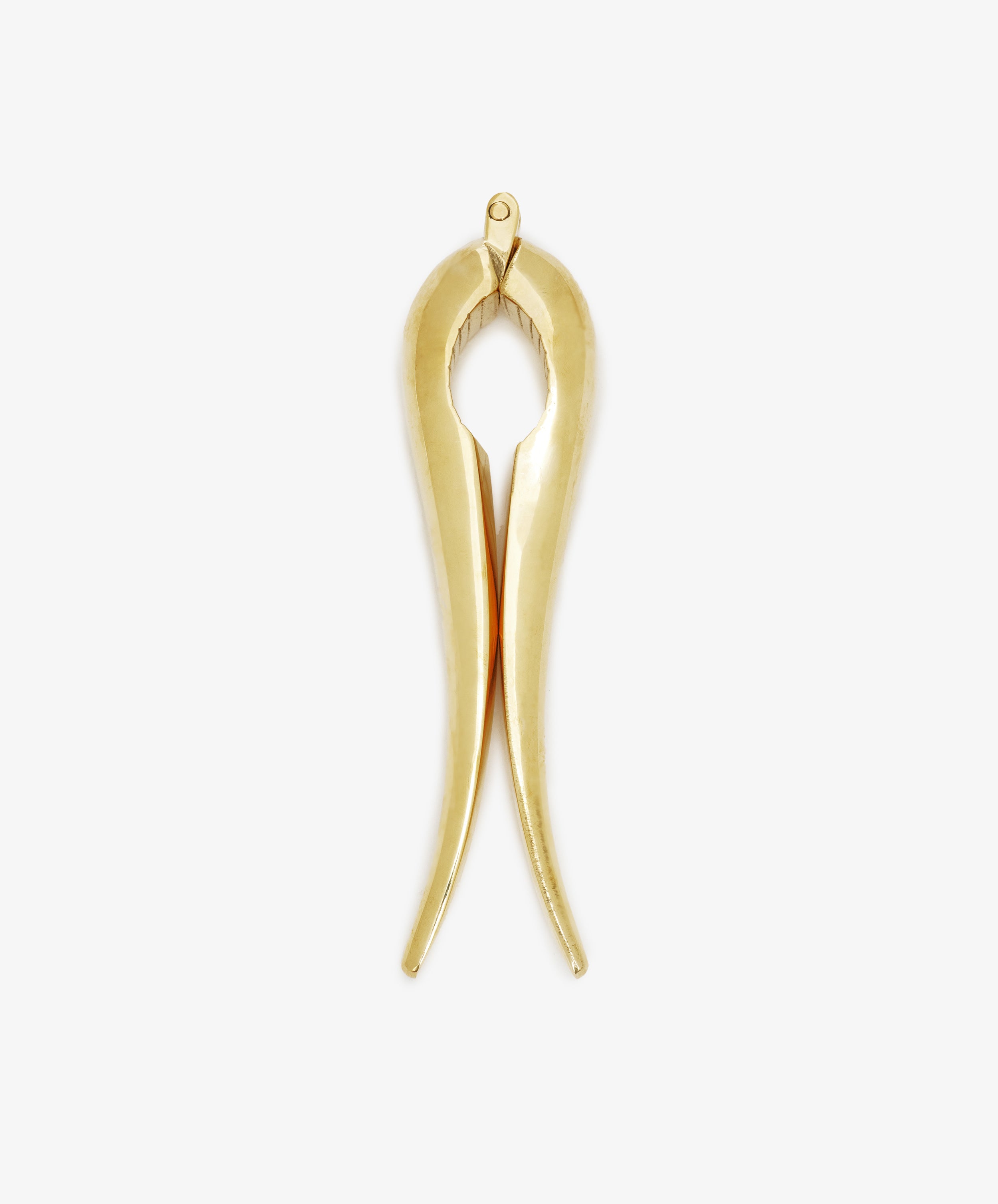 Gold-colored Nutcracker made of brass, shaped like tongs and set against a white background. This modern piece reflects the timeless elegance characteristic of the Auböck workshop’s design tradition.