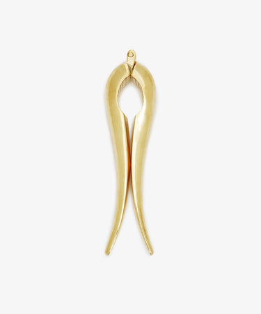 Gold-colored Nutcracker made of brass, shaped like tongs and set against a white background. This modern piece reflects the timeless elegance characteristic of the Auböck workshop’s design tradition.