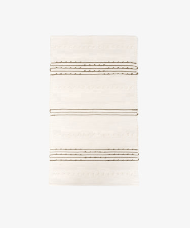 The Gaia Floor Mat is a rectangular handwoven mat with a cream background, featuring evenly spaced horizontal brown stripes and textured patterns in the traditional tapete de trapo style.