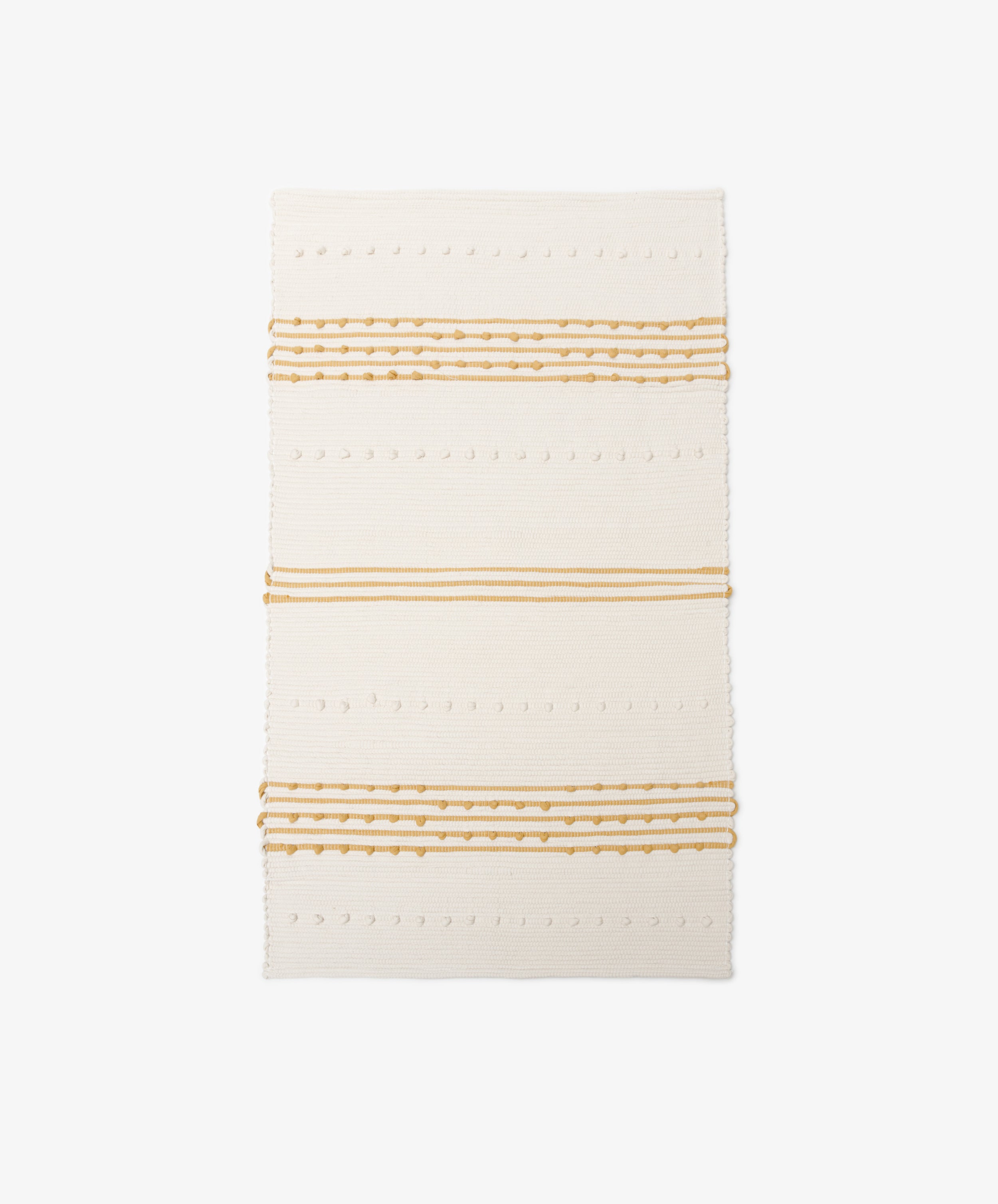 Gaia Floor Mat: A rectangular off-white rug with horizontal mustard yellow stripes and dotted textured patterns, handwoven from recycled fabric in the spirit of Portuguese tradition, shown on a white background.