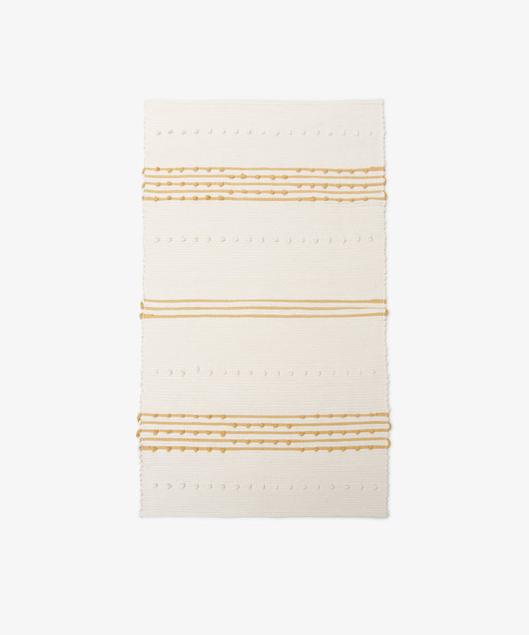 Gaia Floor Mat: A rectangular off-white rug with horizontal mustard yellow stripes and dotted textured patterns, handwoven from recycled fabric in the spirit of Portuguese tradition, shown on a white background.