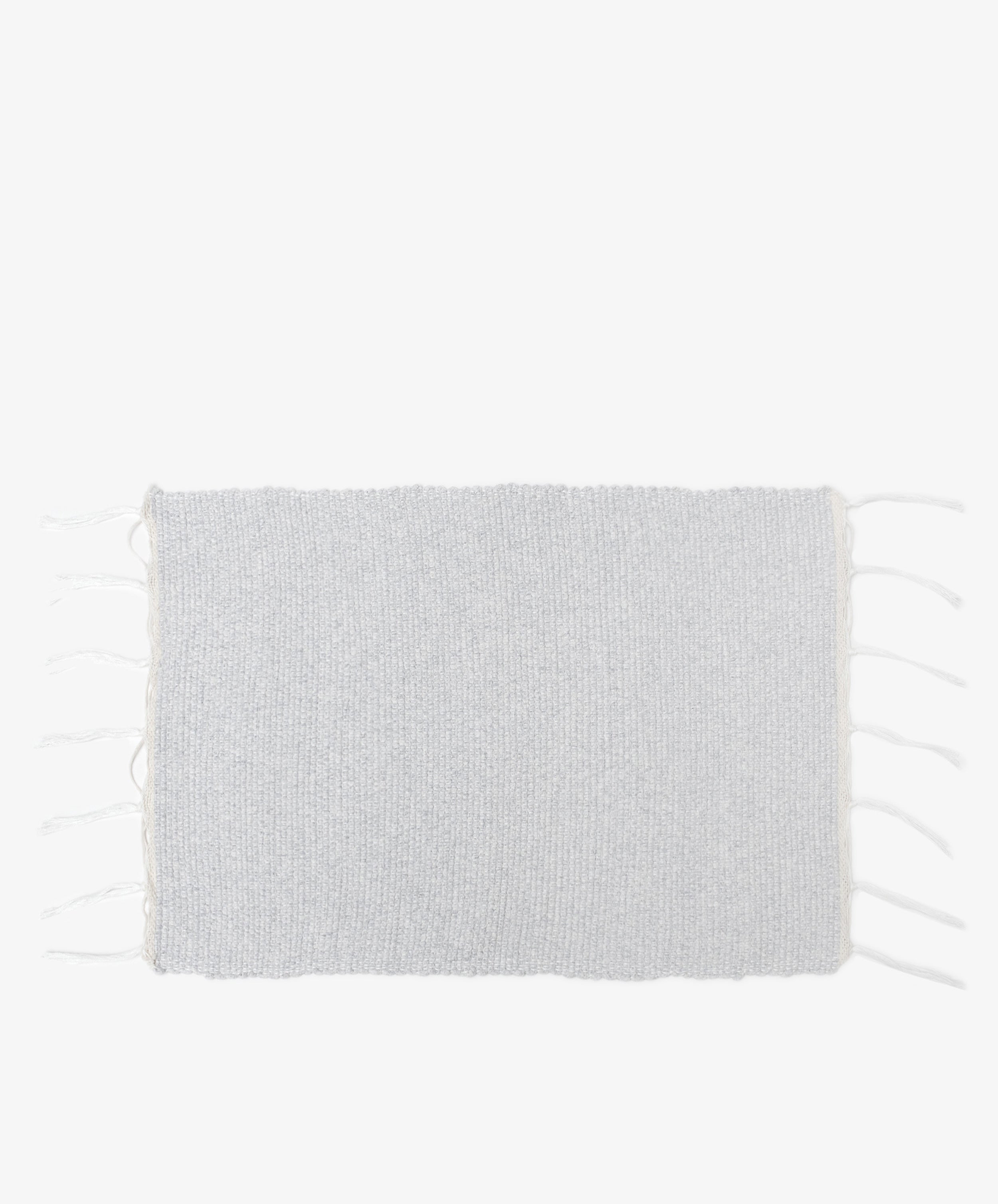 The Gaia Placemat, Set of 6, features rectangular light gray woven mats handwoven in Portugal from recycled fabric with short fringe on the shorter edges, shown against a plain white background.
