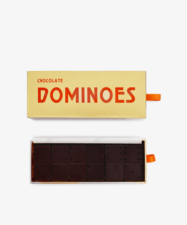 An open rectangular box labeled Chocolate Domino Set displays luxury dark chocolates shaped and marked like dominoes—a delightful holiday gift.