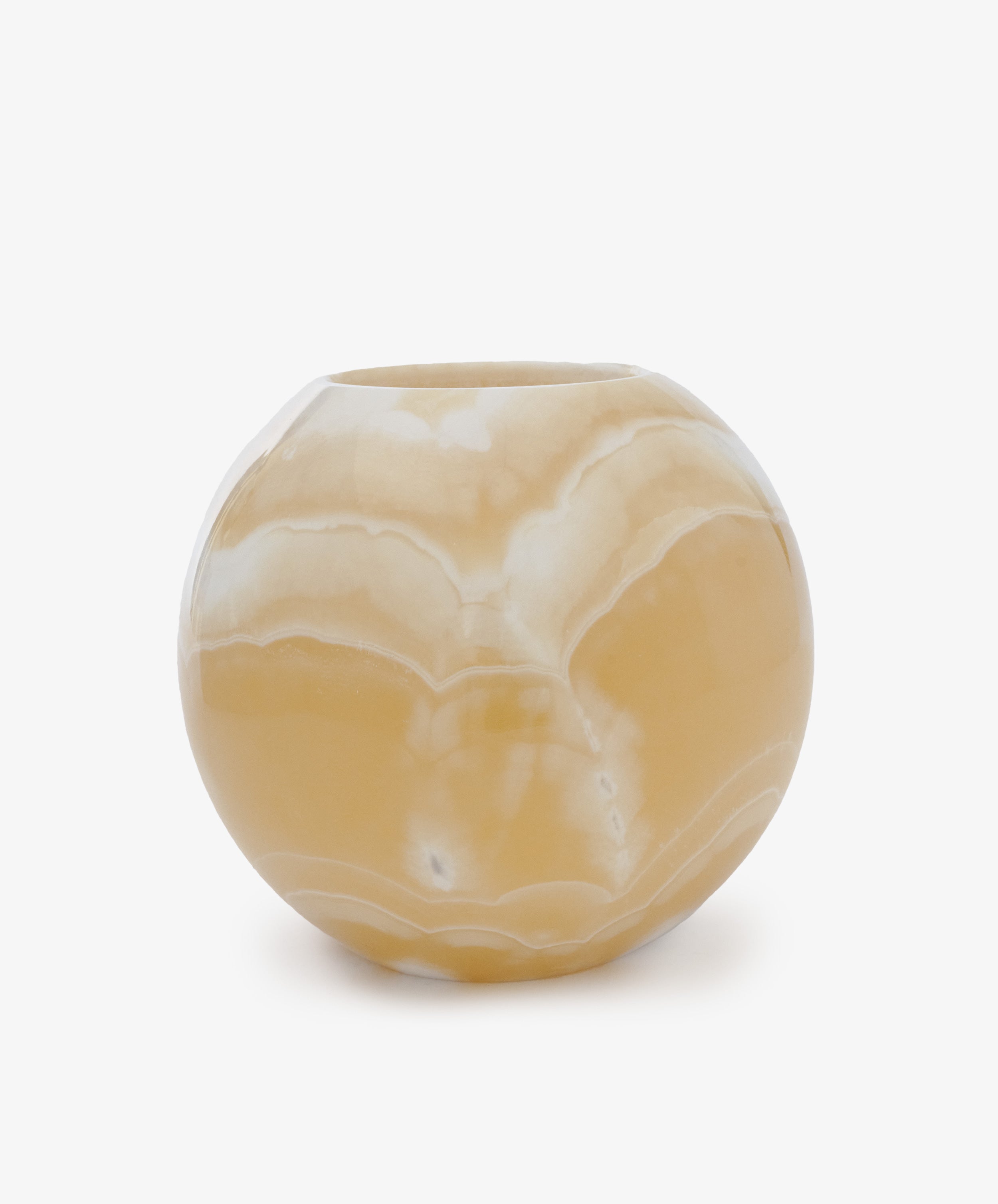 The Akila Candleholder features a round, ochre-colored Egyptian alabaster design with white marbling, shown against a plain white background.