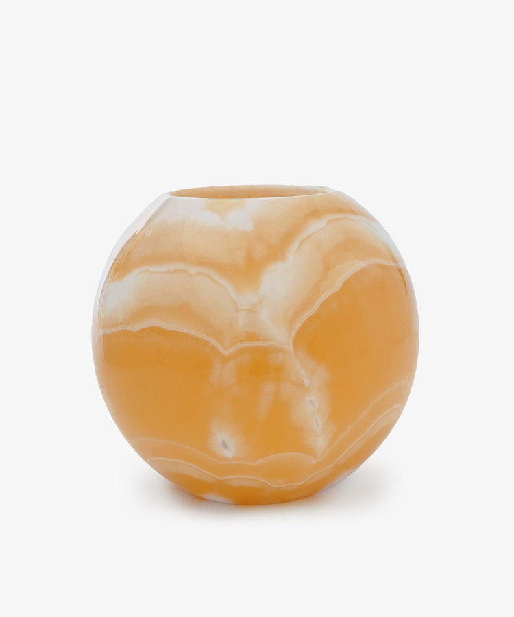 The Akila Candleholder features a round orange and white marbled design with a glossy finish, reminiscent of Egyptian Alabaster from Luxor, displayed against a plain white background.